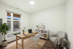 Office space featuring dark wood-style flooring and electric panel