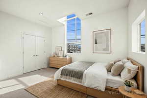 Carpeted bedroom featuring a closet and attic access