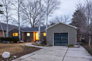 View of front facade with concrete driveway, brick siding, and a garage