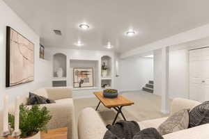 Living room featuring built in shelves and light colored carpet