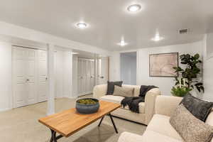 Living area with light colored carpet and baseboards