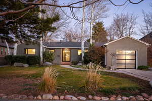 View of front of house featuring a garage, concrete driveway, brick siding, and a front lawn