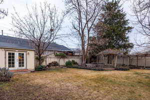 Fenced backyard featuring french doors