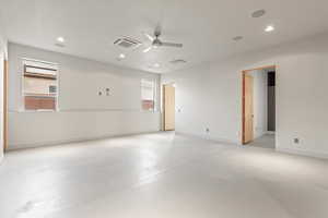 Empty room with concrete floors, ceiling fan, healthy amount of natural light, cooling unit, and recessed lighting