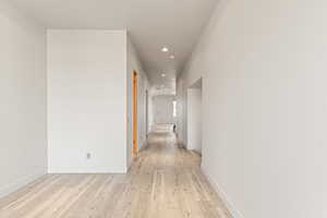 Corridor featuring light wood-type flooring and recessed lighting