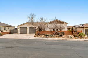 View of front of house featuring a fenced front yard, concrete driveway, a garage, and stucco siding