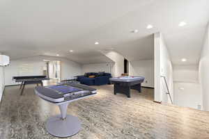 Game room with vaulted ceiling and recessed lighting
