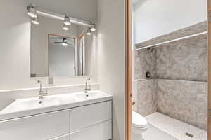 Full bathroom with double vanity and a stall shower