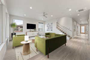 Living room with wood finished floors, a ceiling fan, recessed lighting, and cooling unit