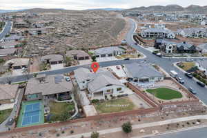 Aerial view of property and surrounding area featuring a mountain backdrop and nearby suburban area