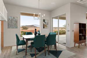 Dining room with a mountain view, light wood-style flooring, and hanging lights