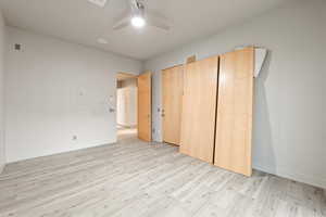 Unfurnished bedroom with light wood finished floors and ceiling fan