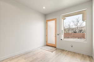 Doorway featuring wood finished floors and recessed lighting