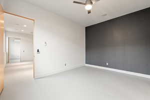 Empty room with finished concrete floors, ceiling fan, and recessed lighting