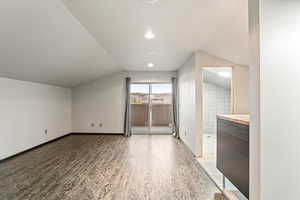 Additional living space featuring light wood finished floors, lofted ceiling, and recessed lighting