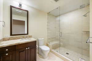 Bathroom featuring a shower stall, vanity, and light tile patterned flooring