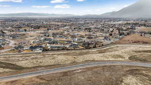 Aerial view of property and surrounding area with a mountainous background and nearby suburban area