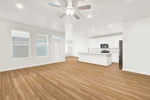 Unfurnished living room with a ceiling fan, and light wood-type flooring
