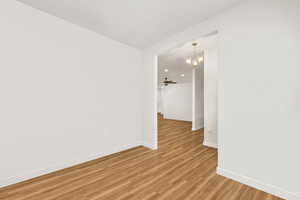Unfurnished room with light wood-style flooring and suspended lighting