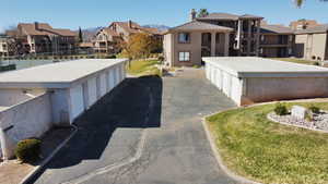 View of asphalt driveway featuring a residential view and community garages