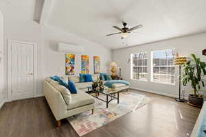 Living room featuring ceiling fan, wood finished floors, and vaulted ceiling with beams