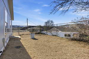 Fenced yard featuring a mountain view and cooling unit
