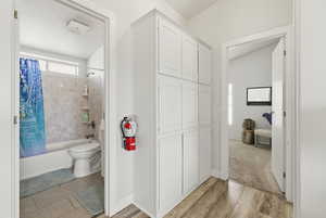 Full bathroom featuring shower / bath combo with shower curtain and light wood finished floors