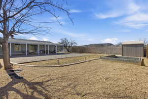 Fenced backyard with a storage unit, a patio, and a garden