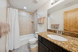 Bathroom with vanity, shower / bathtub combination with curtain, recessed lighting, and light tile patterned floors