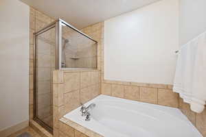 Bathroom featuring a bath and a shower stall