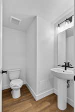 Half bath featuring wood finished floors