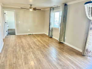 Unfurnished room with ornamental molding, a ceiling fan, and light wood-type flooring