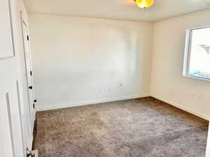 Carpeted spare room with baseboards