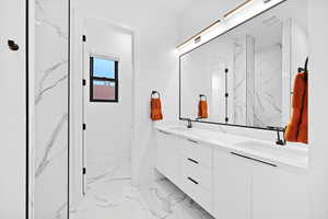 Full bath with double vanity and light marble finish floors