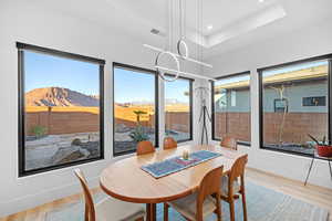 Dining area featuring light wood-style floors, hanging lights, and a mountain view