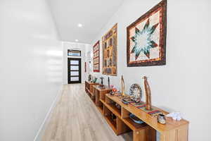 Corridor featuring light wood finished floors and recessed lighting