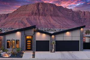Modern home featuring a mountain view, an attached garage, and stucco siding