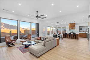 Living room featuring light wood-style flooring, recessed lighting, and a ceiling fan
