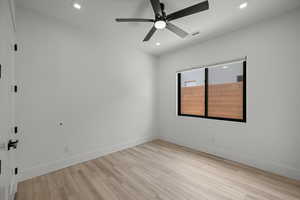 Empty room featuring light wood finished floors, ceiling fan, and recessed lighting