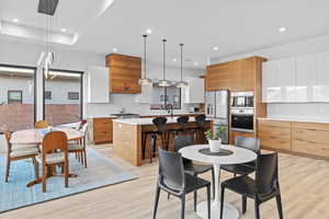 Dining room with light wood-type flooring and recessed lighting