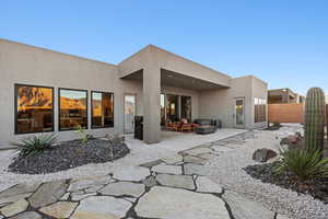 Back of house with a patio, stucco siding, and outdoor seating
