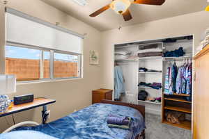 Carpeted bedroom with a closet and a ceiling fan