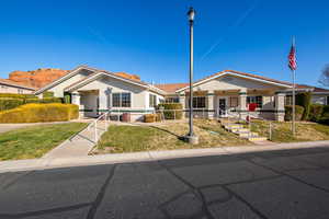 View of front of property with stucco siding, a front yard, and a tiled roof
