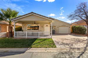 Single story home with stucco siding, driveway, a garage, ceiling fan, and a front lawn