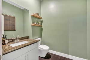 Bathroom featuring vanity and dark tile patterned flooring