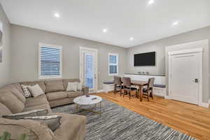 Living room with light wood-type flooring and recessed lighting