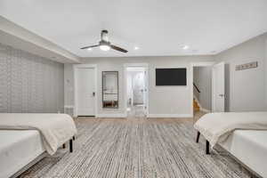 Bedroom with ceiling fan, wood finished floors, recessed lighting, and an accent wall