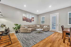 Living area with light wood-style floors and recessed lighting