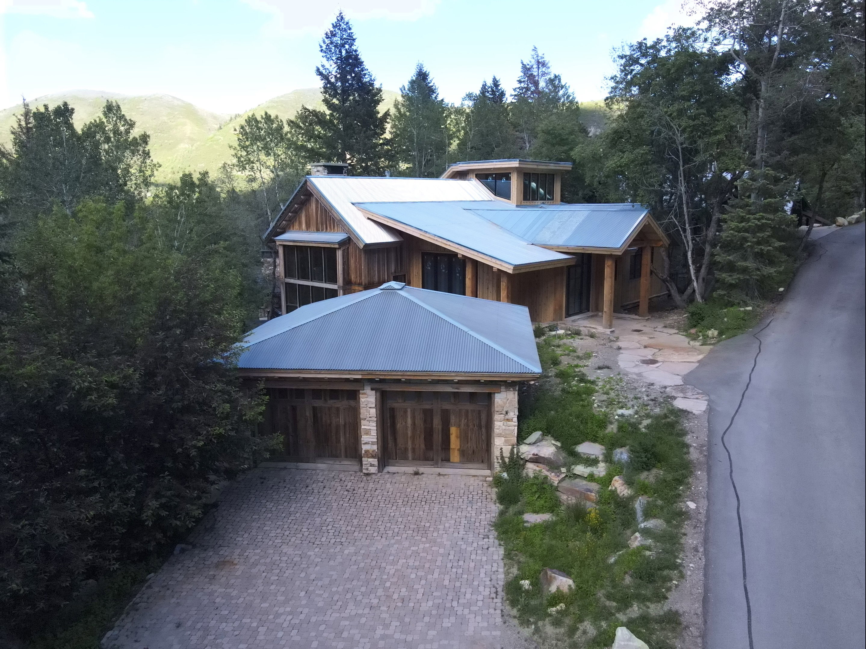 Multi-level architectural design featuring wood siding and a metal roof
