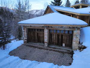Snow covered garage featuring a mountain view